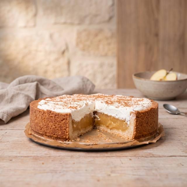 Apfeltorte mit Sahnehaube und Zimt, ein Stück angeschnitten – Pampered Chef® Rezept