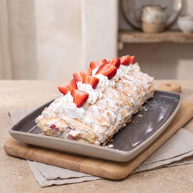 Baiserrolle gefüllt mit Vanillecreme und Erdbeeren, mit Sahnetupfen dekoriert – Pampered Chef® Rezept