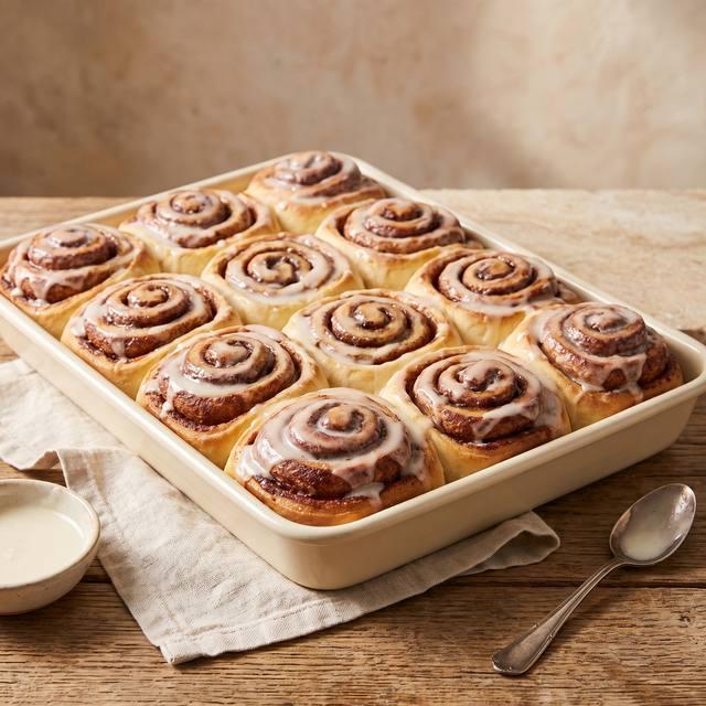 Fluffige Cinnamon Rolls mit Frischkäse-Frosting nebeneinander in einer Backform – Pampered Chef® Rezept