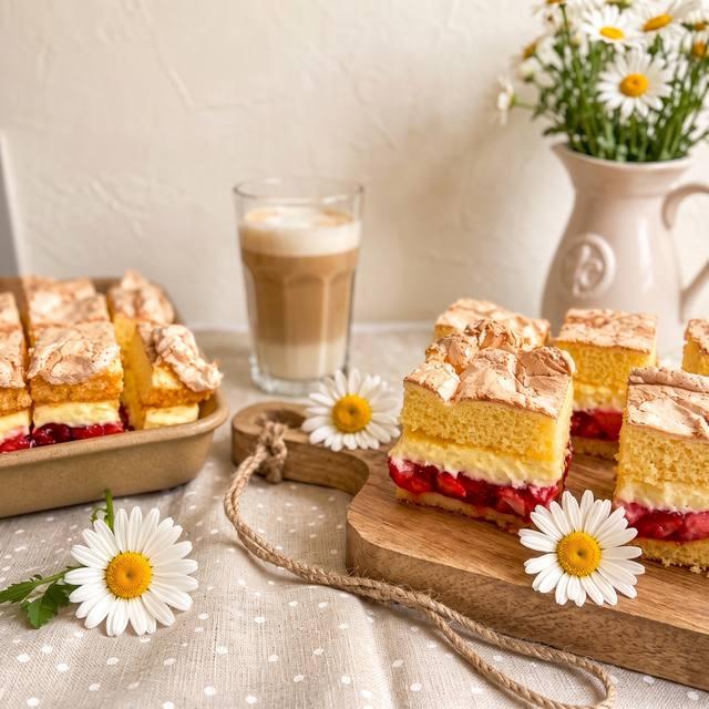 Angeschnittener Erdbeer-Baiser-Kuchen mit sichtbaren Schichten aus Baiser-Boden, Creme und Erdbeer-Füllung – Pampered Chef® Rezept