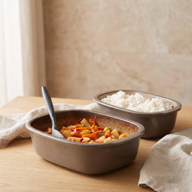 Hähnchen süß-sauer mit Ananas, Paprika und Möhren im Ofenmeister, daneben Reis – Pampered Chef® Rezept
