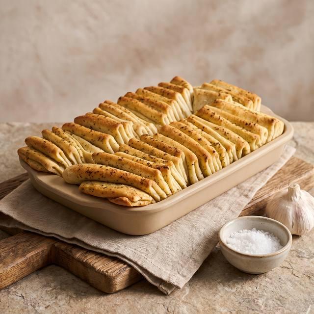 Kräuterfaltenbrot mit Kräuterbutter, dicht gefaltet in einer rechteckigen Backform – Pampered Chef® Rezept