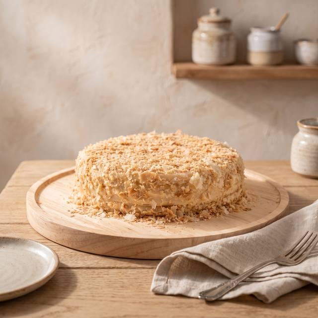 Runde Napoleon-Torte mit Blätterteigbröseln auf einem Holzbrett – Pampered Chef® Rezept