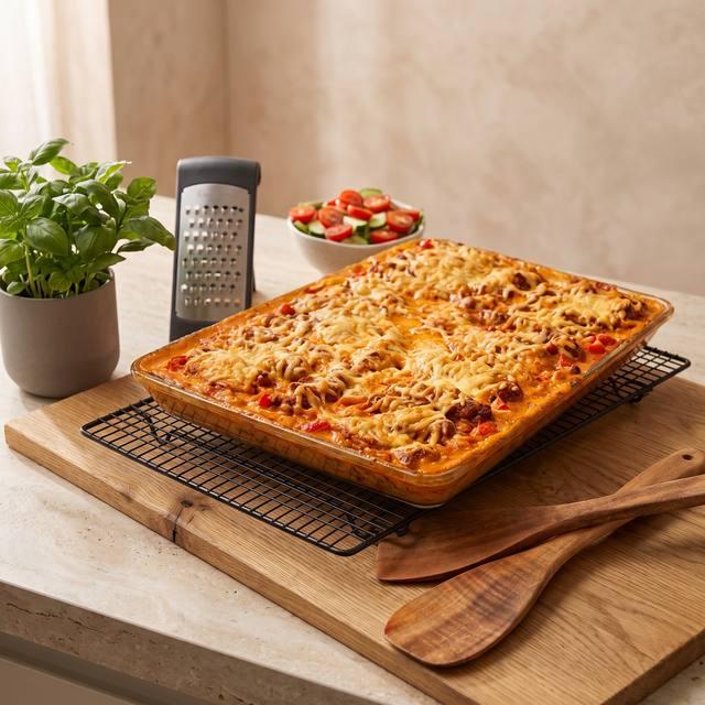 Überbackenes Paprika-Sahne-Hähnchen mit Knöpfle in cremiger Soße auf dem Pampered Chef® Großen Ofenzauberer Plus, daneben ein Kuchengitter