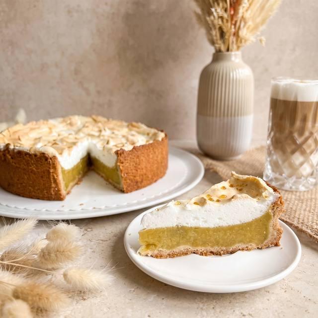 Angeschnittene Rhabarberpudding-Baiser-Torte mit cremiger gelber Füllung und luftigem Baiser-Topping – Pampered Chef® Rezept