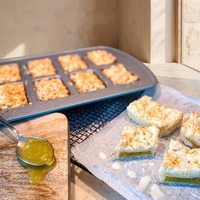 Blätterteig-Rhabarbertörtchen mit Streuseln und Zuckerguss, angeschnitten mit sichtbarer Rhabarber-Füllung – Pampered Chef® Rezept