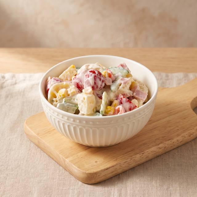 Tortellini-Salat mit Paprika, Mais und Kochschinken in einer weißen Schüssel – Pampered Chef® Rezept